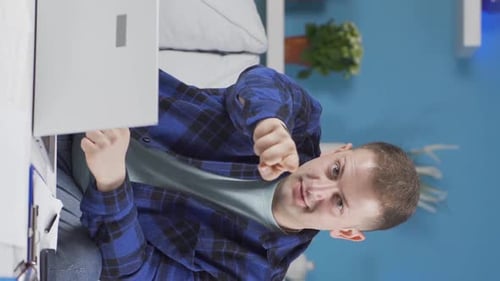 Vertical video of Home office worker man makes a trust sign to the camera.