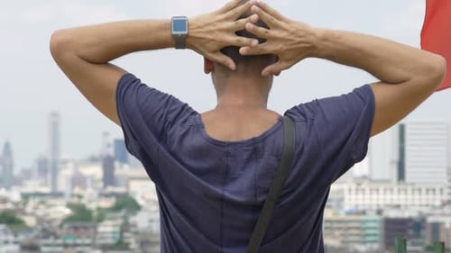 Young Man Stretching Arms and Admire Cityscape View on Terrace 120fps