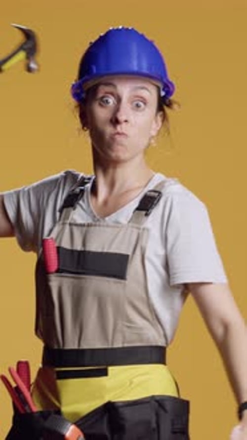 Vertical Video Portrait of Aggressive Constructor Threating with Hammer