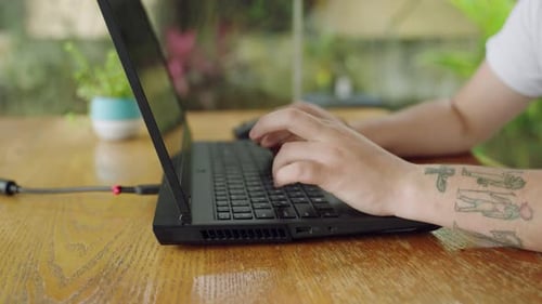 Tattooed Developer Types Code on Laptop Tech Work in Progress Programming Debugging on Notebook