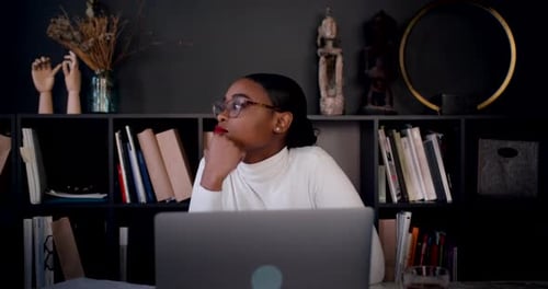 Selbstisolationsporträt einer schönen jungen, nachdenklichen Afrikanerin, die von zu Hause aus online arbeitet