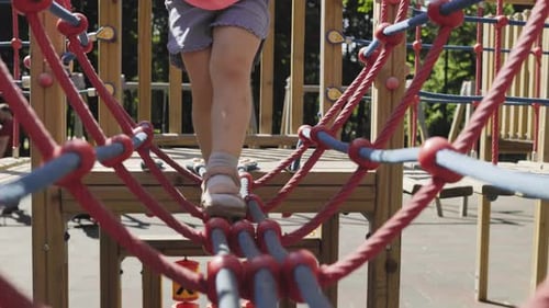 Joyful Child Playing and Sliding on the Playground