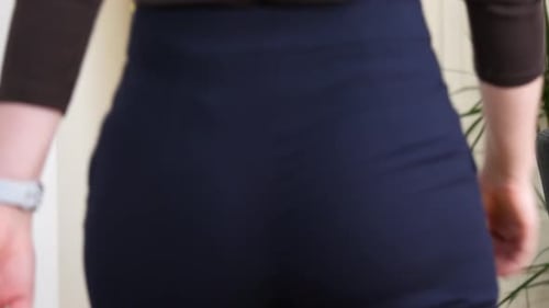 Tall woman feels sudden severe pain in buttocks area, clutch and massage. Medium shot, real time