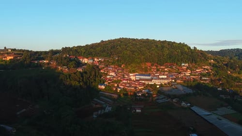 Village and Greenhouses Seen From a Drone in a Forested Area Near the Mountains