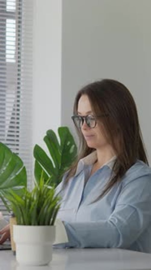 A Dedicated and Focused Professional Woman is Seen Working Efficiently in a Modern Office Space