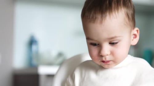 Adorável menino comendo alguma coisa. Adorável garoto caucasiano com rosto manchado. De perto.