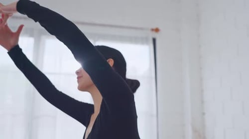 Graceful Woman Stretching Arms in a Light Studio
