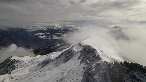 This stunning drone footage captures a flyover of a mountain as the first snow of the season blanket
