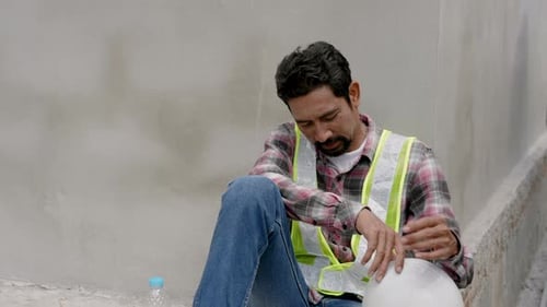 Engineer, Indian man, housing project Building construction frame Sitting against the wall Open a he