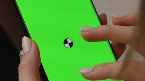 Hand using smartphone with green screen