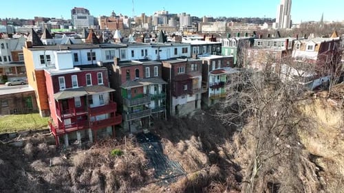 Rundown houses on side of cliff. Dangerous housing neighborhood. Aerial rising shot.