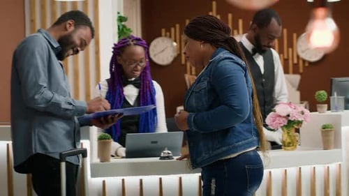 Man Signs in at Hotel Front Desk