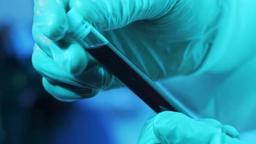 Gloved Hands Extracting Sample from Vial in Lab