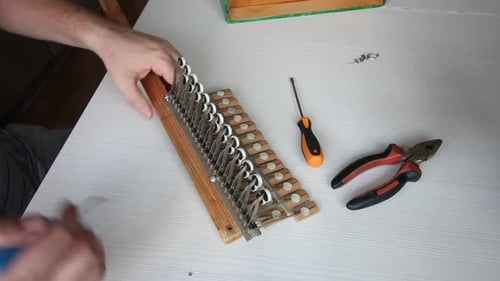 Repair Of Accordion. A Man Checks The Work Of The Accordion Key Block.