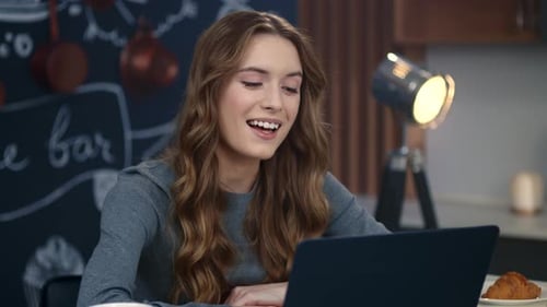 Woman Video Calling on Laptop in a Kitchen