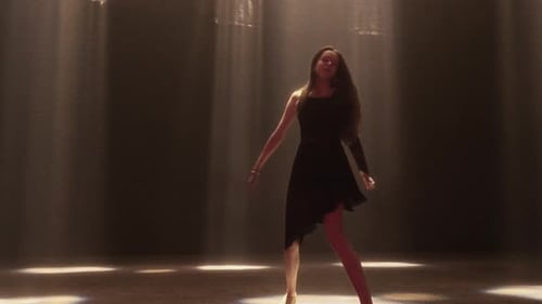 Young Female Dancer Performing Elegantly in Black Under Spotlights
