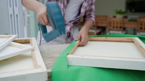 Precisando de decoração, mulher afro-americana segurando tecido verde na varanda com pistola elétrica azul