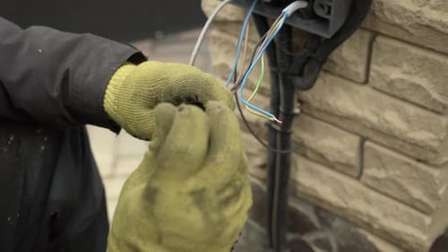 Electrician Connects Wiring to Terminal Block Close Up