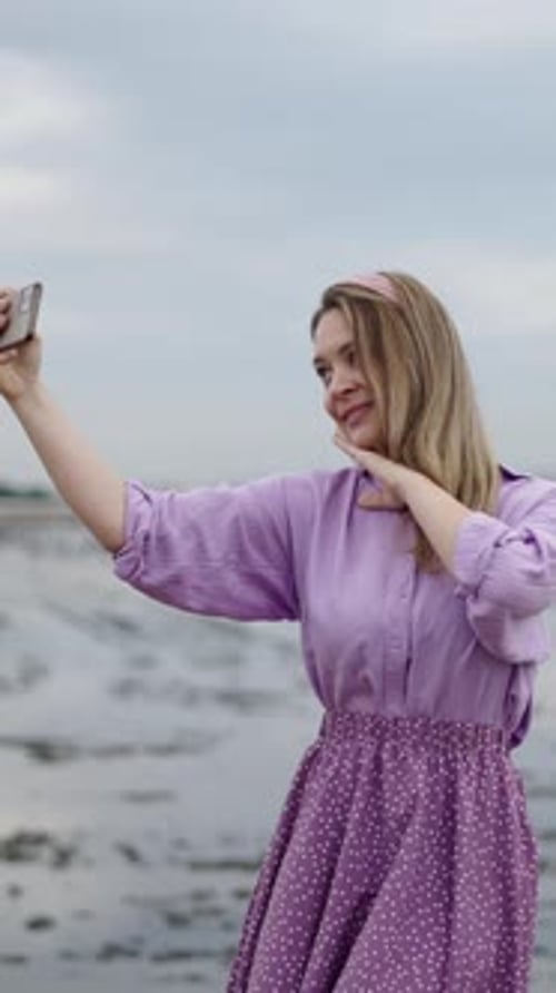 Una mujer vestida de morado graba un Vídeo para 8M