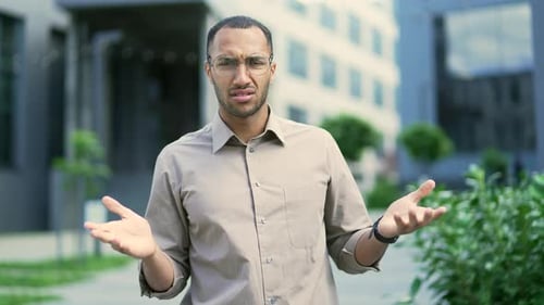 Confused Man Shrugs Shoulders Outdoors