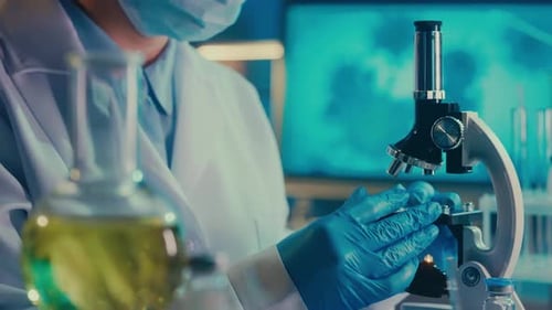 Scientist Examines Sample Through a Microscope in Lab