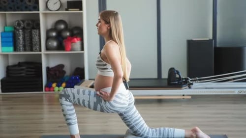 Pregnant Woman Exercising Doing Lunges Indoors