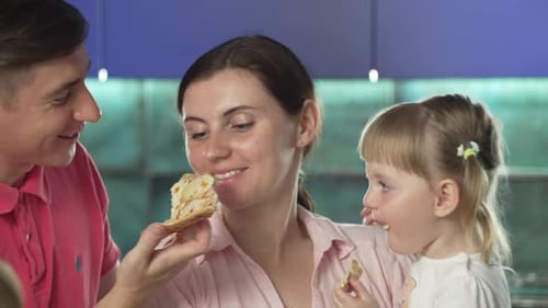 Happy Family Eating Pizza Together at Home