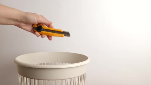 E28. A clerical knife is thrown into the trash can. Disposal of household waste.