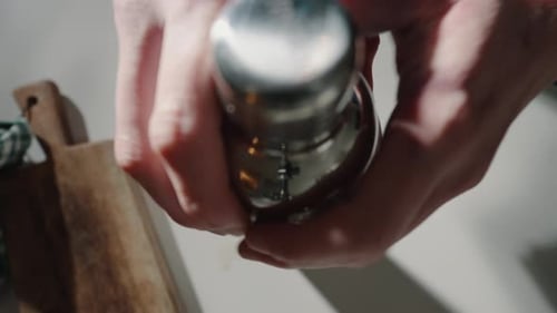 Hands Shaking Cocktail Shaker with Ice