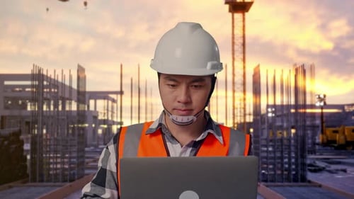 Nahaufnahme eines asiatischen männlichen Ingenieurs, der auf einer Baustelle an einem Laptop arbeitet