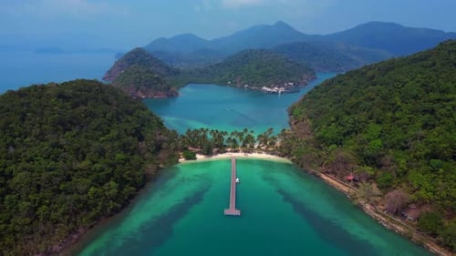 Island with pier leading to tropical beach. Unique aerial view flight drone