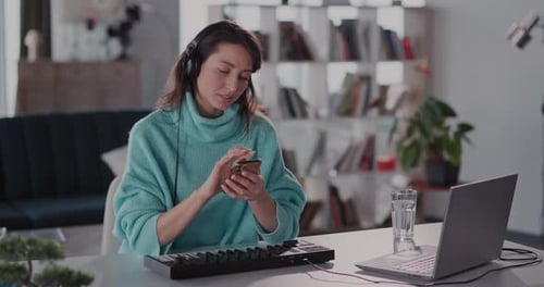 A Young Woman Engaged in Remote Work While Seated Comfortably in a Cozy Home Office Space