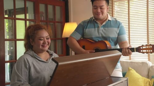Woman Plays Piano, Man Plays Guitar, Singing Together