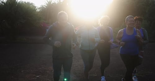 Fit senior people running at city park - Group of elderly friends doing sport workout together