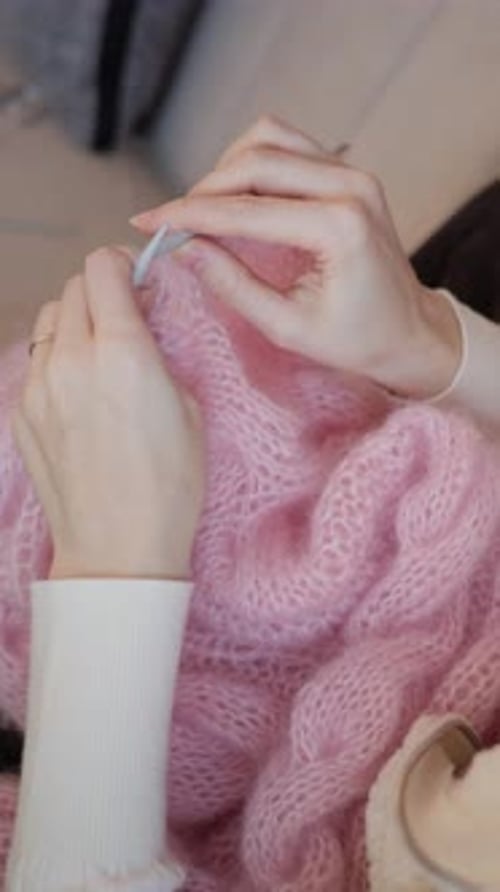 Woman Knitting a Pink Wool Scarf Indoors