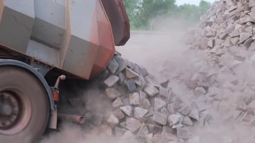 Dump Truck Unloading Metal Pieces at Workplace