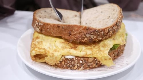 Cutting Egg Sandwich with Knife and Fork