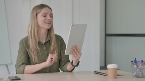 Woman Using Tablet for Video Call in Office