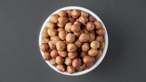 Bowl of Shelled Hazelnuts on Gray Background