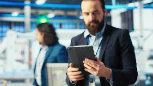 Specialist Sitting on Desk Using Tablet to Inspect Solar Plant Machinery