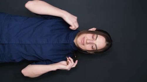 Médico generalista profesional que sonríe positivamente posando con una bata azul de médico con endoscopio