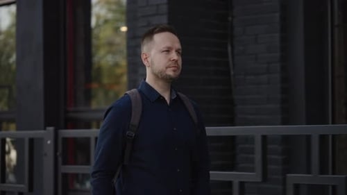 A Young Man in a Good Mood Walks Along a City Street Portrait of a City Guy in a Shirt and with a