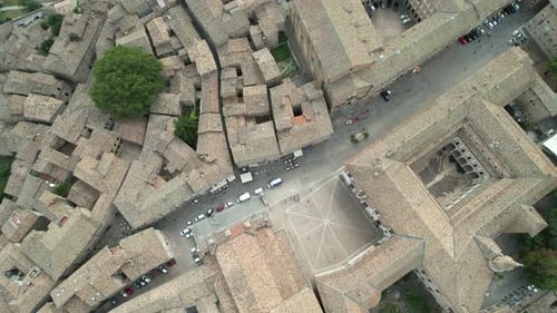 Aerial shot of the Palazzo Ducale di Urbino showcasing its courtyard, tightly packed medieval street