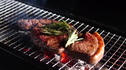 Beef steak is grilled on flame and smoke. Grilled steak with charcoal stove.