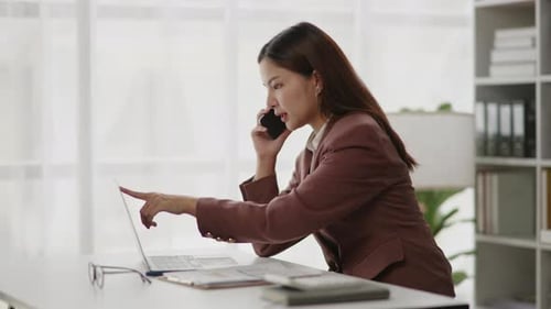 Woman Talking on Cell Phone at Desk Working