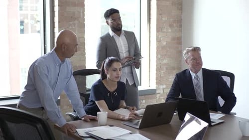 Professionals collaborate on project in sunlit office