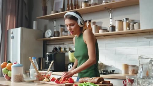 Woman Chopping Vegetables in Sunny Kitchen