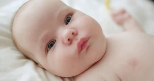 Closeup of Sweet Little Baby Face Lying in Bed