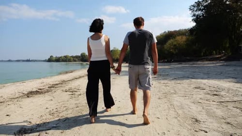 Romantic Couple Walking Barefoot on Sandy Beach