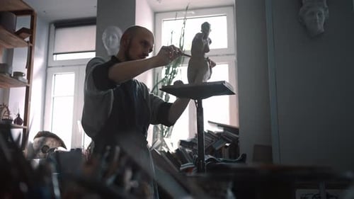 Craftsman Sculptor in Working Uniform Makes a Limestone Copy of Woman Torso at a Creative Workshop